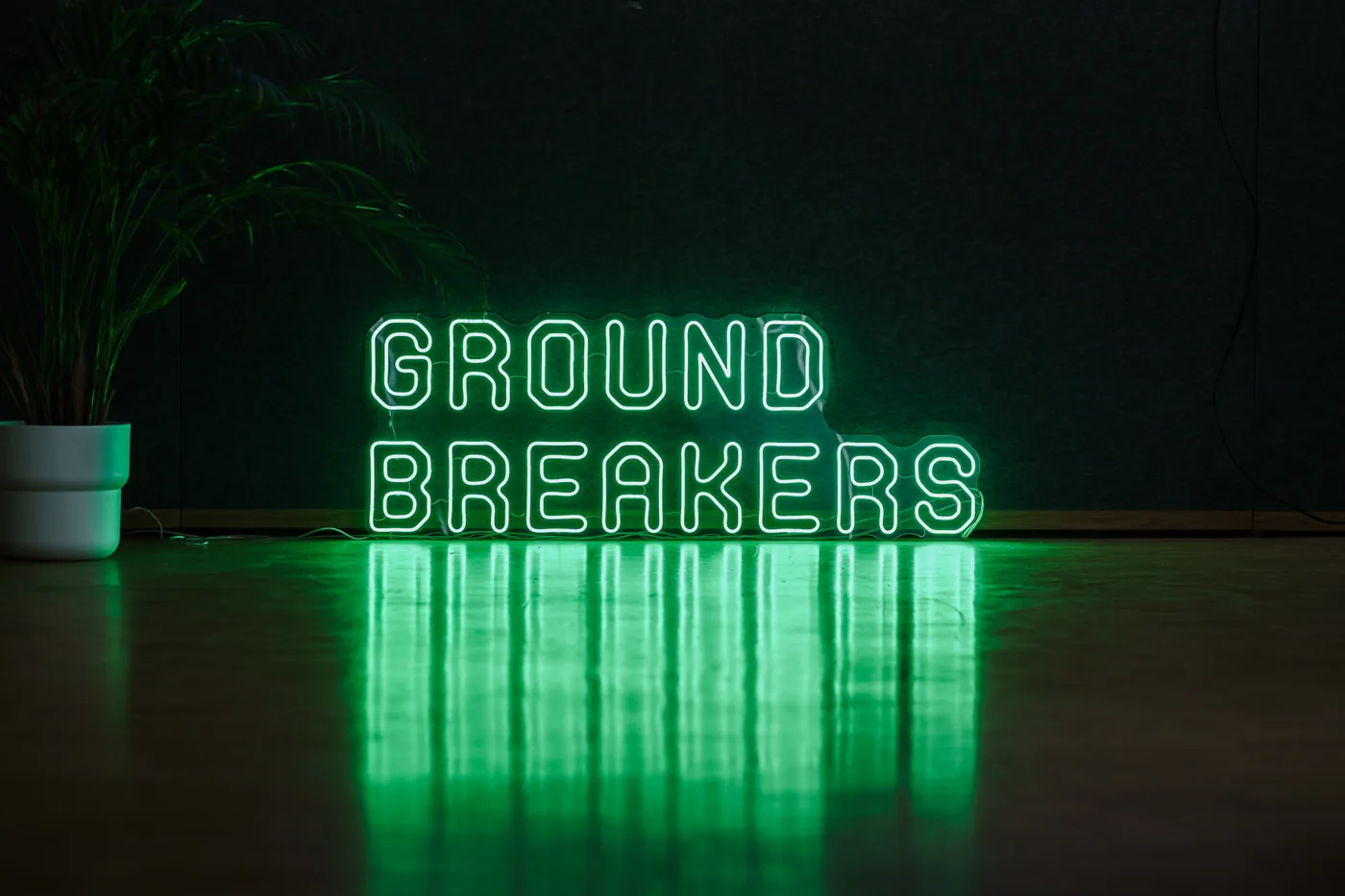Leuchtschrift GROUNDBREAKERS im Clubhouse