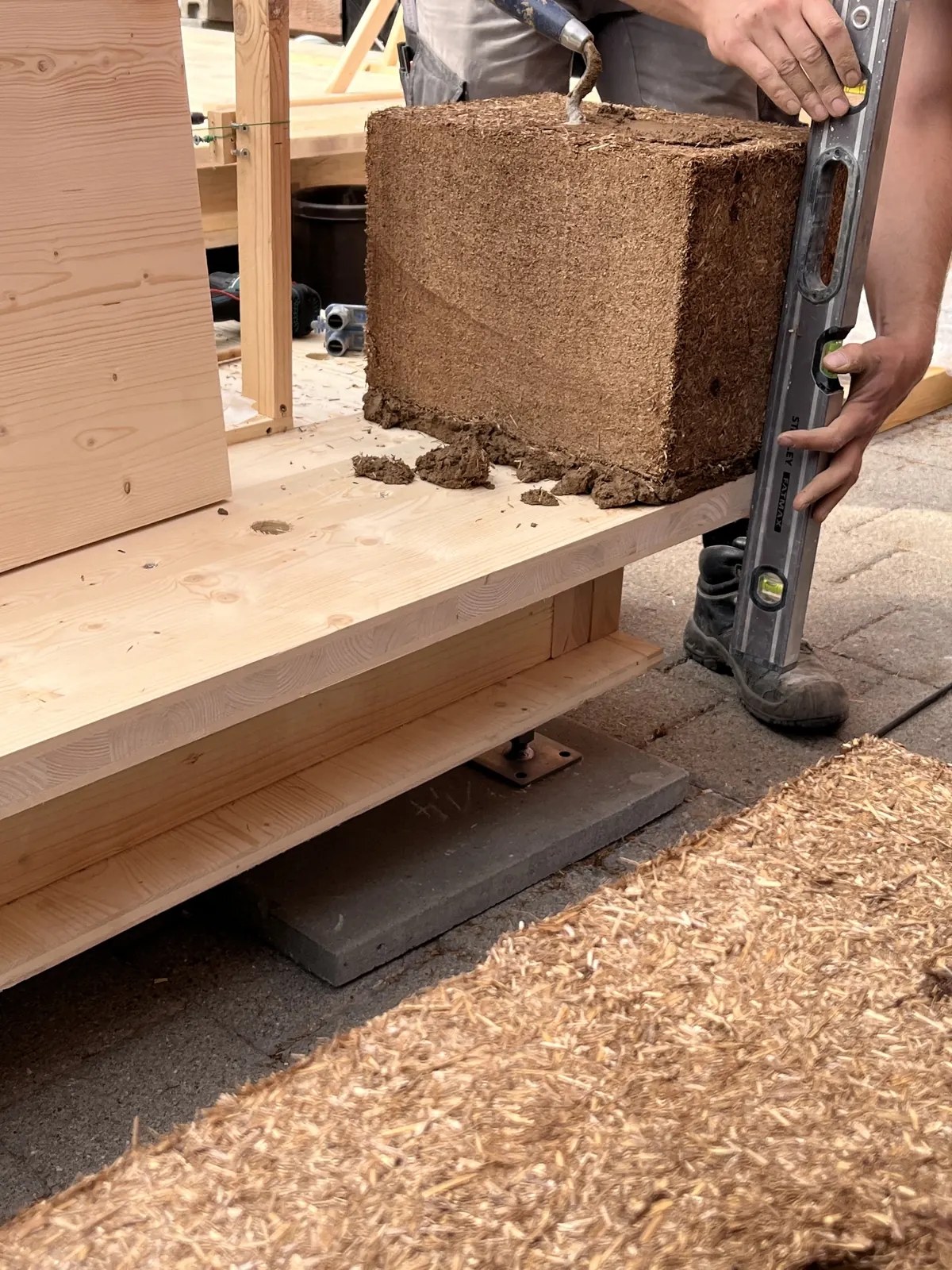 StrawBrick-Aufbau – ein Stein wird mit der Wasserwaage ausgerichtet