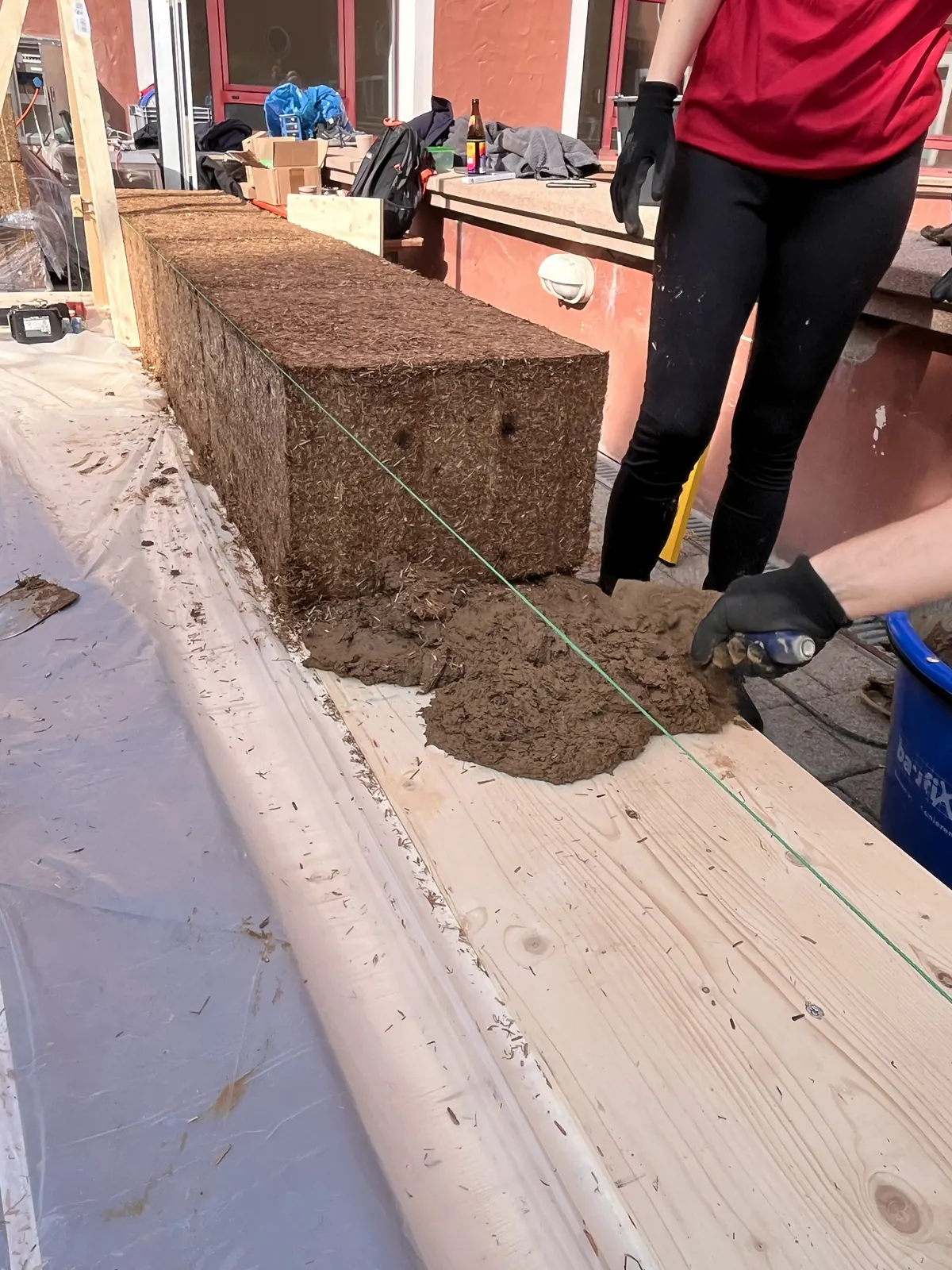StrawBrick-Aufbau – die Steinreihe wird in Mörtel gesetzt